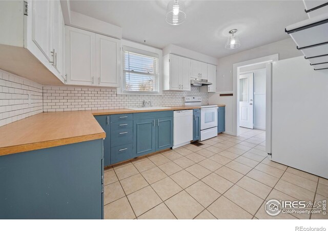 405 Maple St, Fort Morgan, CO 80701 - kitchen with white appliances, blue cabinetry, under cabinet range hood, backsplash, and white cabinets