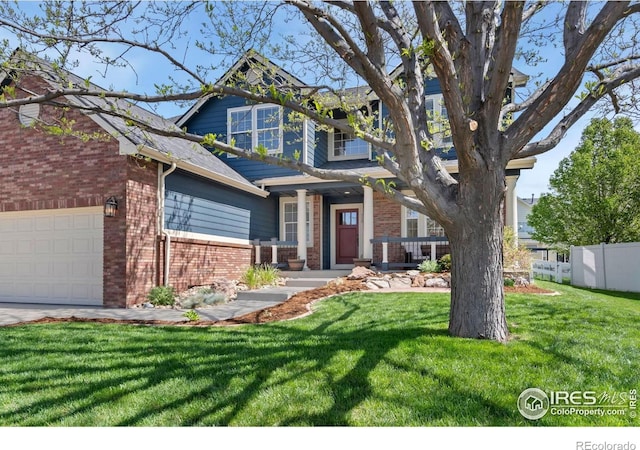 craftsman-style house with a garage, fence, a front yard, and brick siding