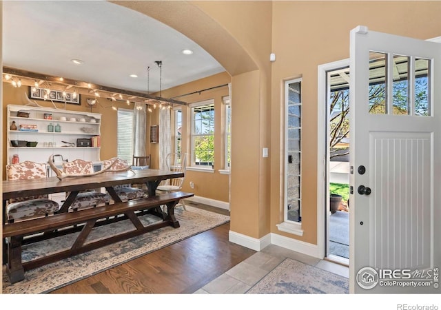 foyer with arched walkways, baseboards, recessed lighting, and wood finished floors