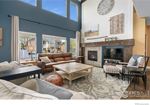 living area featuring a high ceiling, a healthy amount of sunlight, and a fireplace