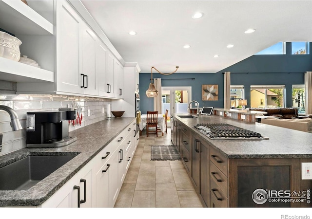 kitchen featuring recessed lighting, a sink, open shelves, and backsplash