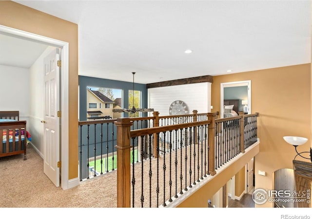 hallway with baseboards, carpet, recessed lighting, and an upstairs landing