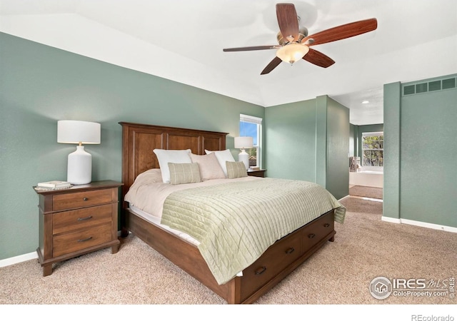 bedroom featuring baseboards, vaulted ceiling, visible vents, and light carpet