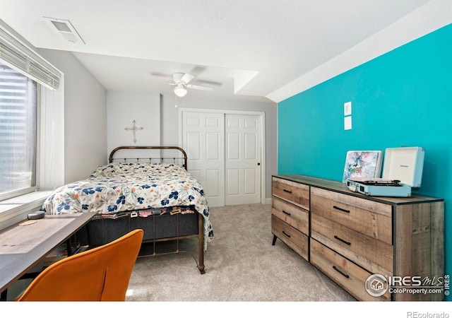 bedroom with carpet flooring, a ceiling fan, lofted ceiling, visible vents, and a closet