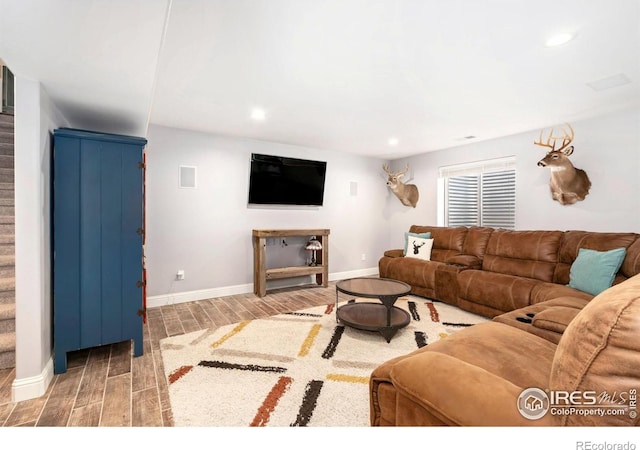 living area with wood tiled floor, visible vents, stairs, baseboards, and recessed lighting