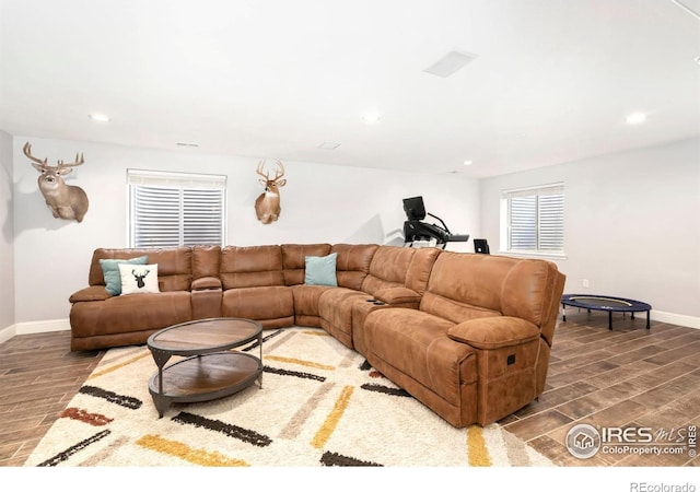 living room with recessed lighting, baseboards, and wood finished floors