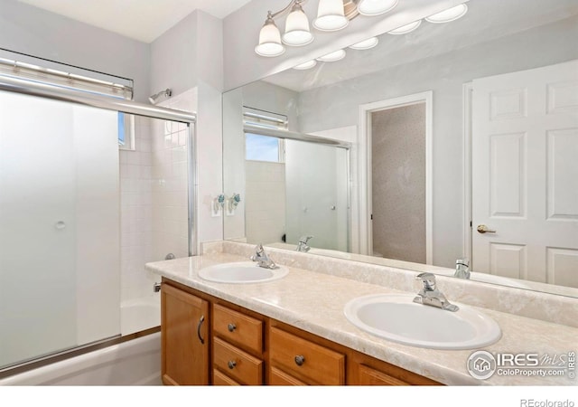 bathroom with double vanity, a sink, and enclosed tub / shower combo