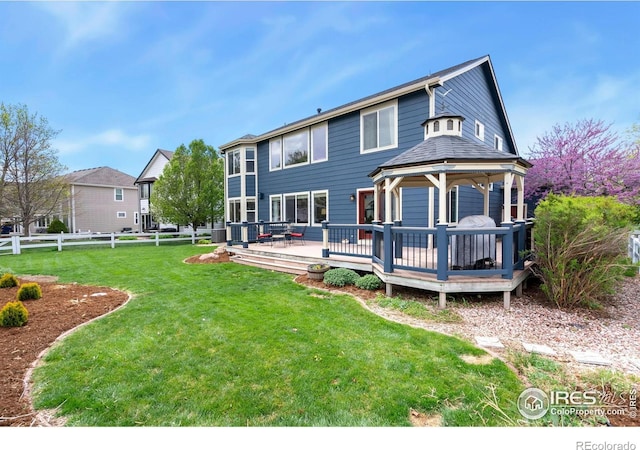 back of house featuring a gazebo, fence, a yard, and a deck