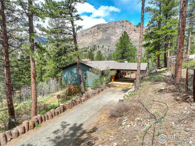 4 Porphyry Vw, Jamestown, CO 80455 - view of front of property with dirt driveway, a mountain view, and a carport