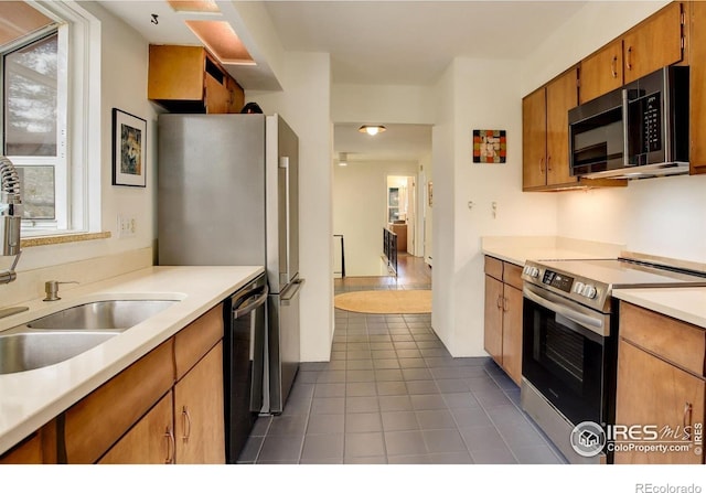 4 Porphyry Vw, Jamestown, CO 80455 - kitchen with appliances with stainless steel finishes, dark tile patterned flooring, brown cabinets, light countertops, and a sink