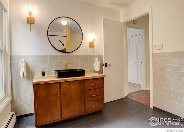 4 Porphyry Vw, Jamestown, CO 80455 - bathroom with tile walls, a baseboard heating unit, tile patterned floors, vanity, and wainscoting