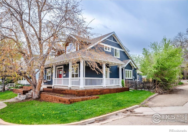 view of front facade featuring fence, a porch, and a front yard