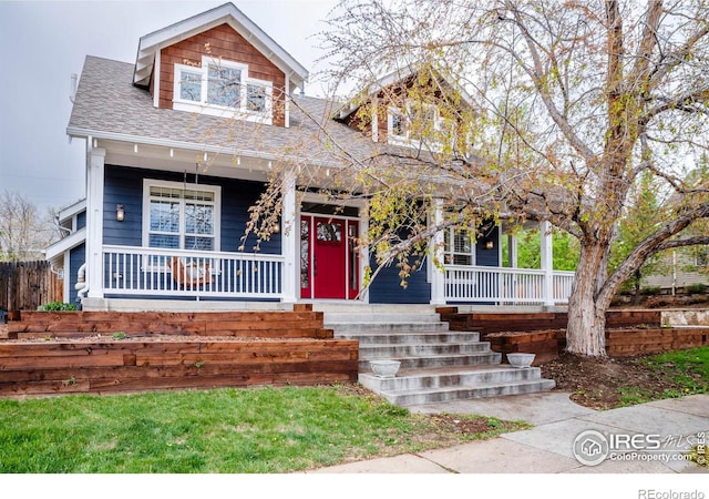 craftsman-style house with covered porch, fence, and a shingled roof