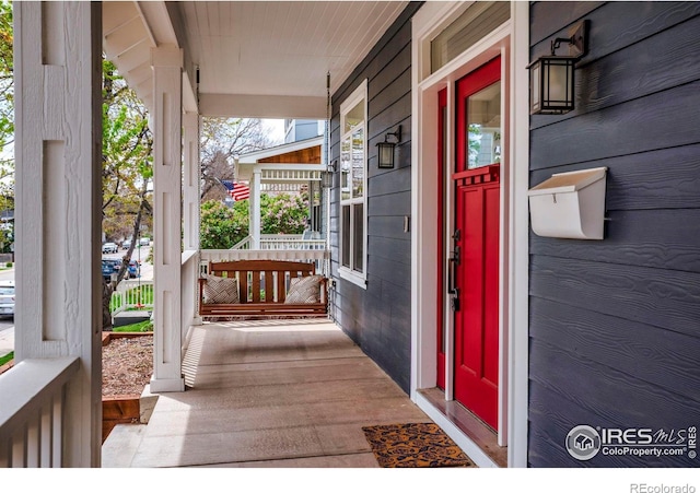 view of exterior entry featuring covered porch