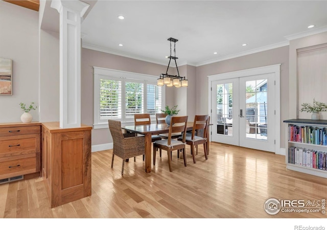 dining room featuring a healthy amount of sunlight, french doors, and light wood-type flooring