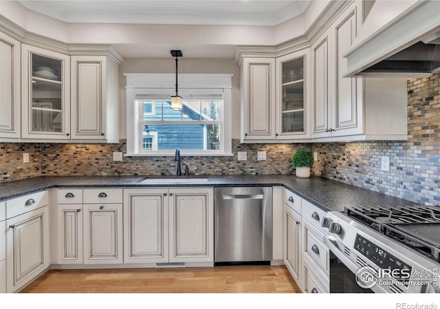 kitchen with a sink, dark countertops, custom exhaust hood, and stainless steel appliances
