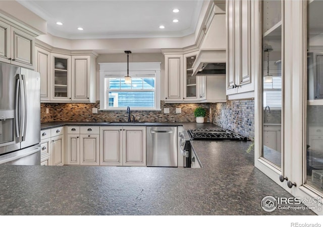 kitchen featuring backsplash, dark countertops, appliances with stainless steel finishes, and a sink
