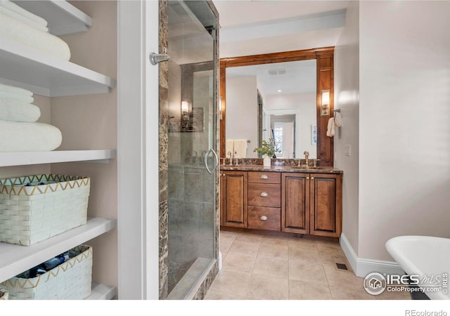 bathroom with a sink, double vanity, tile patterned floors, baseboards, and a stall shower