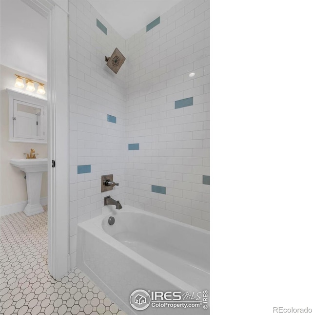 bathroom featuring baseboards and bathing tub / shower combination