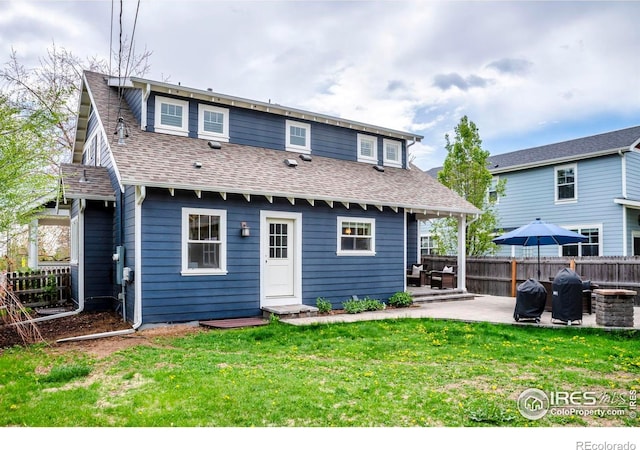back of property featuring a yard, a patio, fence, and roof with shingles