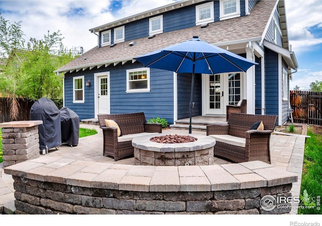 back of house with fence, roof with shingles, a patio, and french doors