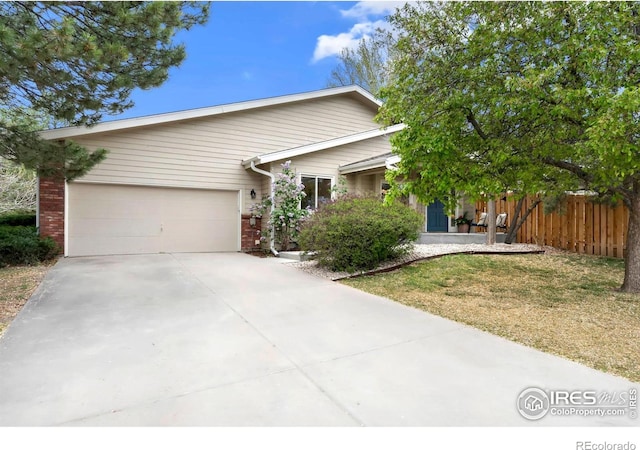 single story home with an attached garage, fence, driveway, and brick siding