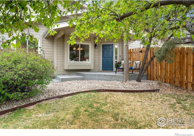 doorway to property featuring fence and covered porch