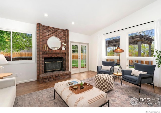 living room featuring french doors, recessed lighting, baseboards, wood finished floors, and lofted ceiling