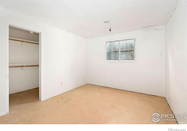 unfurnished bedroom featuring visible vents, a spacious closet, and a closet