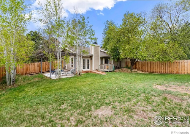 view of yard featuring a deck, french doors, a fenced backyard, and a patio area