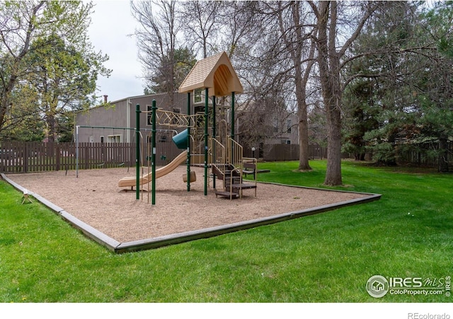 community play area featuring a yard and fence