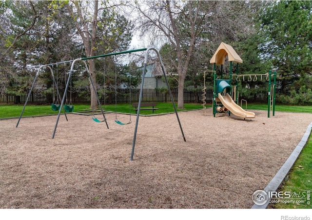 community playground featuring a yard and fence