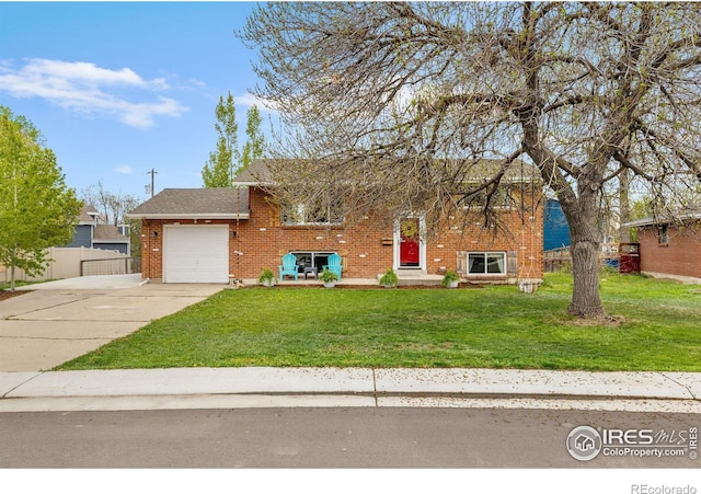 view of front of property with driveway, a front yard, brick siding, fence, and an attached garage