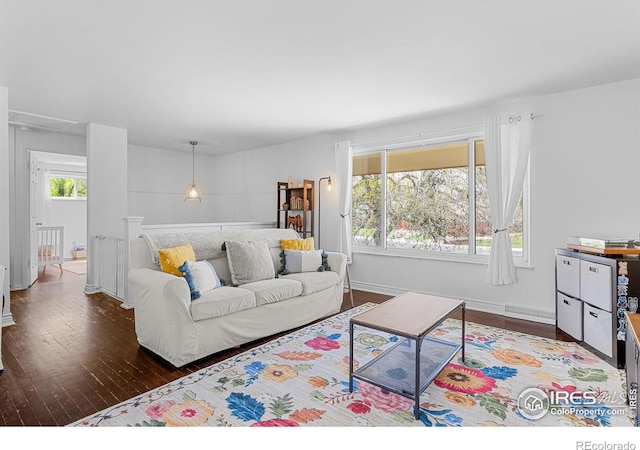 living area with baseboards, a wealth of natural light, wood finished floors, and attic access
