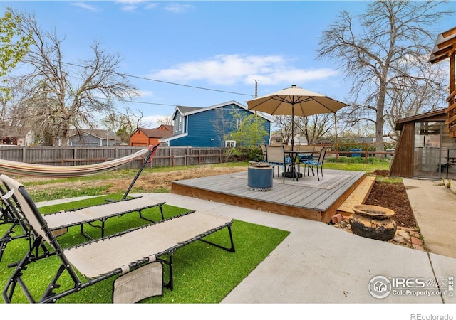 exterior space with a fenced backyard, outdoor dining area, and a deck