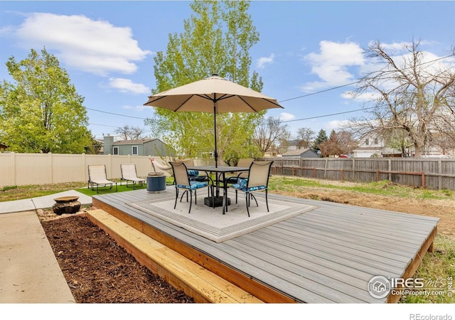 wooden terrace featuring a fenced backyard and outdoor dining space