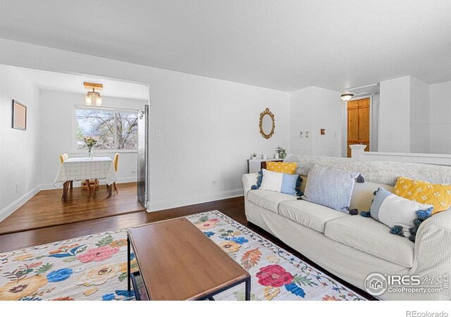 living room featuring baseboards and dark wood-style floors