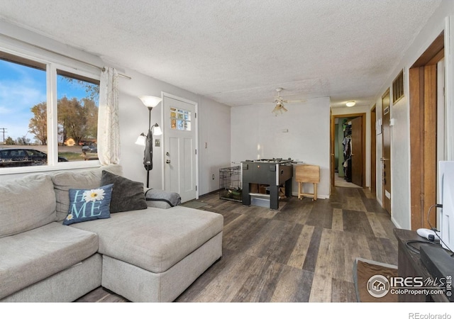 living room featuring a textured ceiling, wood finished floors, and visible vents
