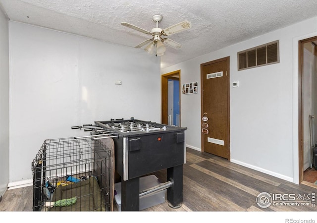 playroom featuring baseboards, ceiling fan, wood finished floors, and visible vents