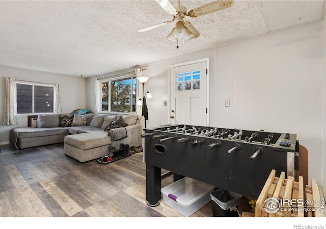 playroom with a textured ceiling, ceiling fan, and wood finished floors