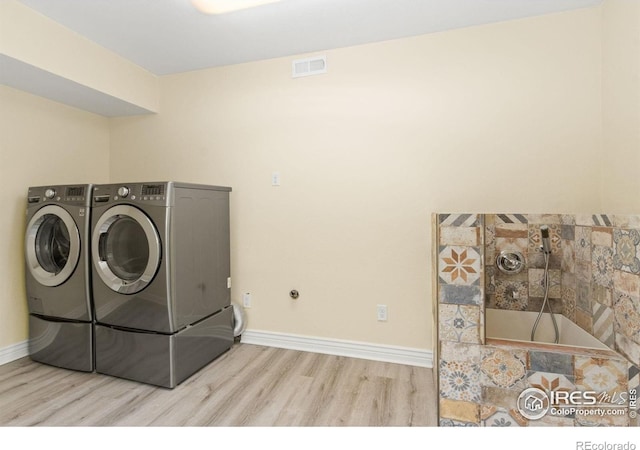 washroom with independent washer and dryer, laundry area, baseboards, wood finished floors, and visible vents