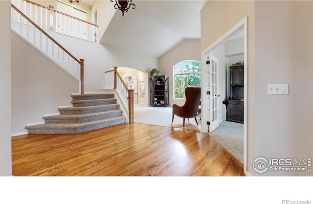 1442 Mallard Dr, Johnstown, CO 80534 - foyer featuring stairs, arched walkways, wood finished floors, lofted ceiling, and baseboards