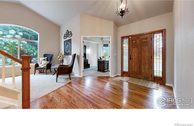 1442 Mallard Dr, Johnstown, CO 80534 - foyer with lofted ceiling, wood finished floors, healthy amount of natural light, and stairway