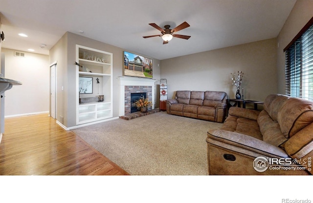 1442 Mallard Dr, Johnstown, CO 80534 - living room with built in features, ceiling fan, a fireplace, wood finished floors, and baseboards