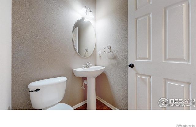 1442 Mallard Dr, Johnstown, CO 80534 - half bath featuring wood finished floors, toilet, and baseboards