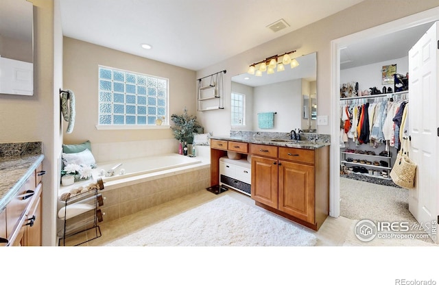 1442 Mallard Dr, Johnstown, CO 80534 - full bath featuring plenty of natural light, vanity, a garden tub, tile patterned floors, and recessed lighting