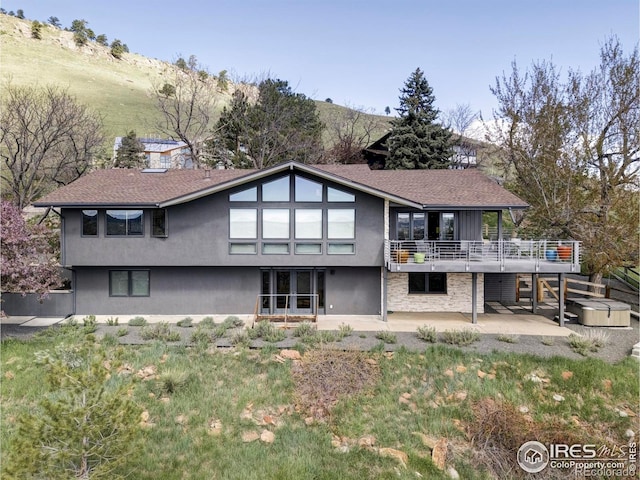 back of property with a patio area, stucco siding, and a mountain view