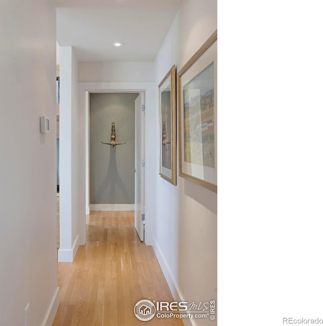 corridor featuring light wood-type flooring, recessed lighting, and baseboards