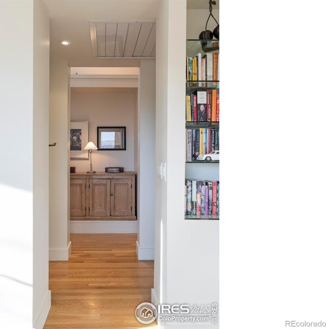 hallway featuring recessed lighting, light wood finished floors, and baseboards