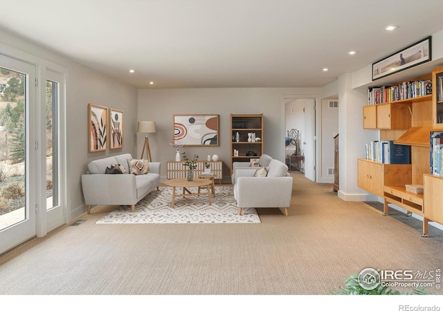 carpeted living area with baseboards, recessed lighting, and visible vents